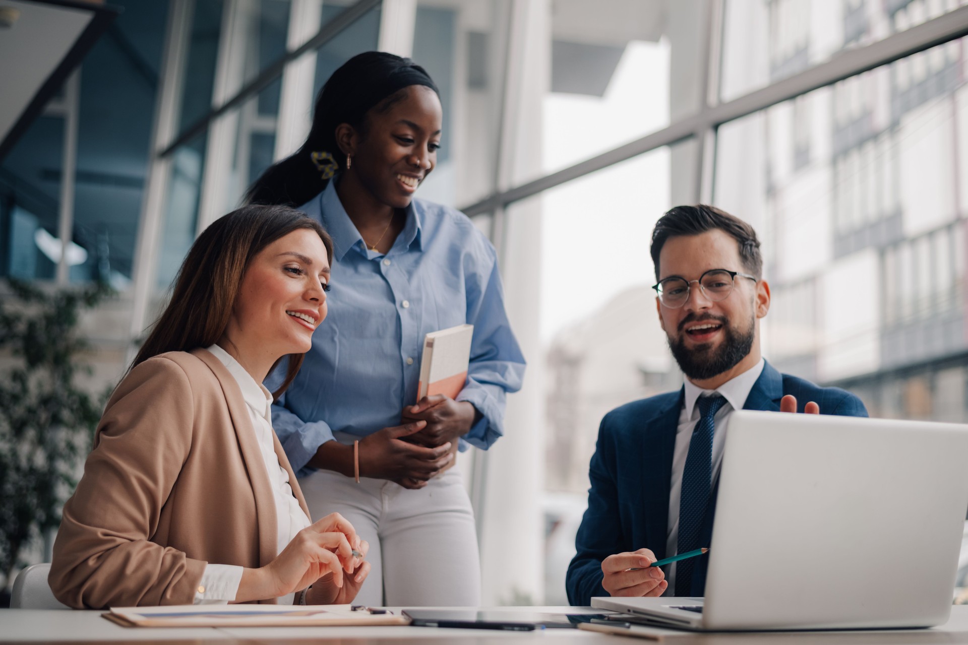 Business team working together on a project using laptop in modern office